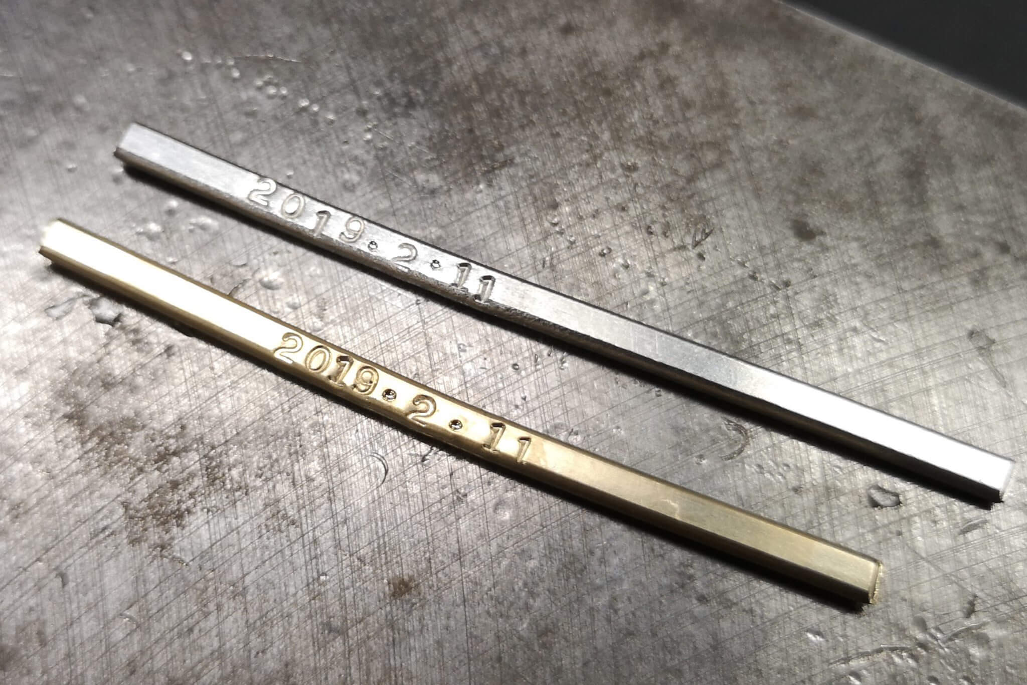 Ground metal for handmade wedding rings with engraved text.