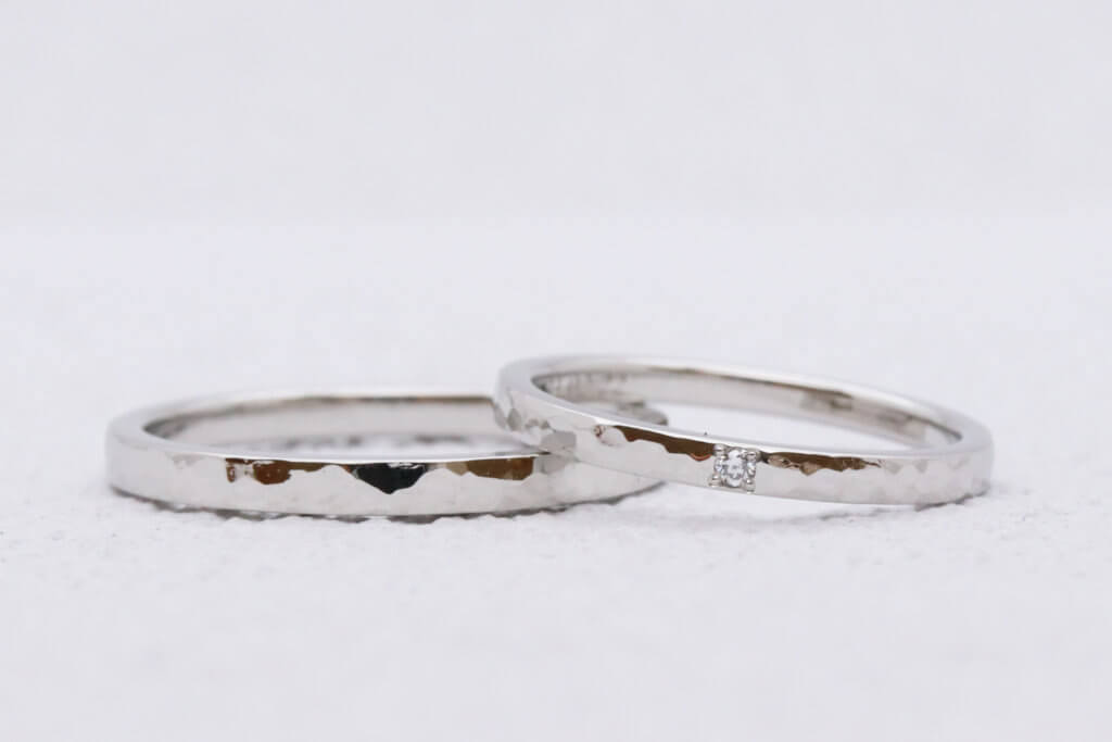 Platinum wedding band with hammered pattern and diamond accents