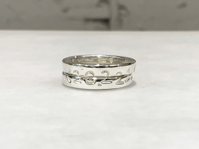 A pair of rings that become one design when two rings are put together.