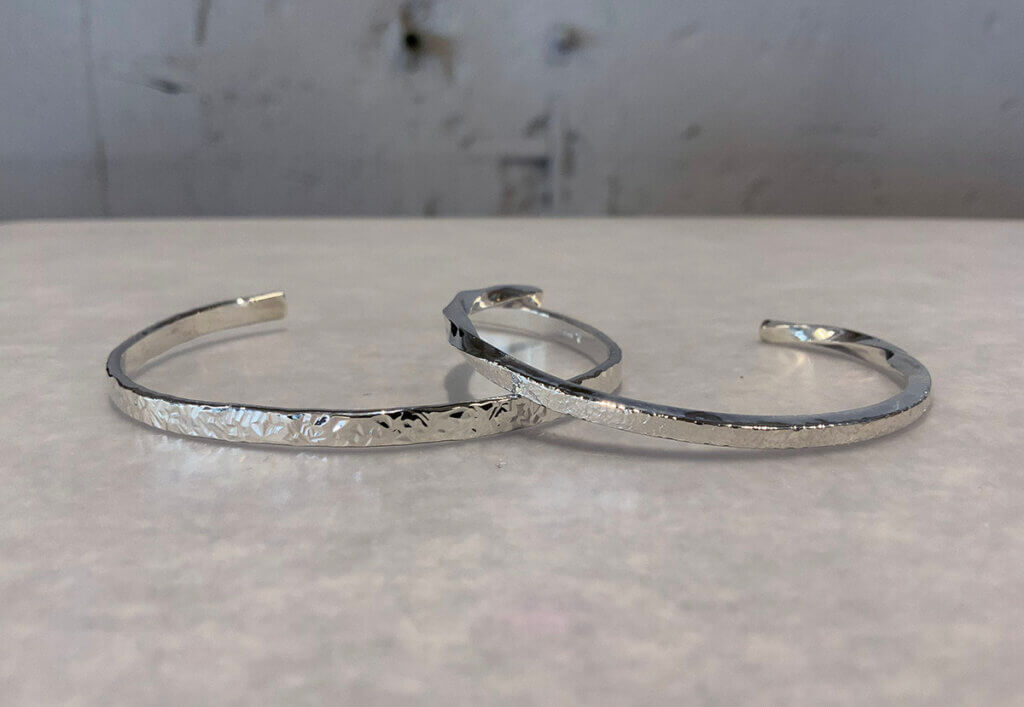 Silver bangle with stellar and snowflake patterns